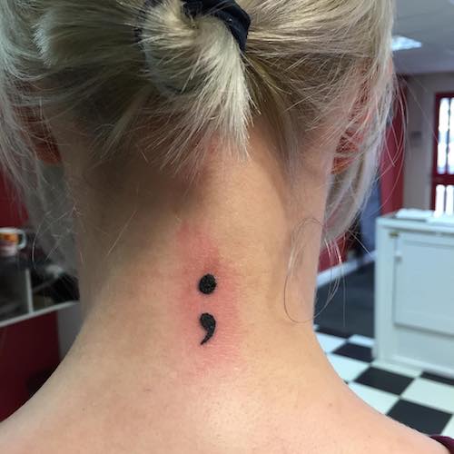 back of neck tiny tattoo - semicolon